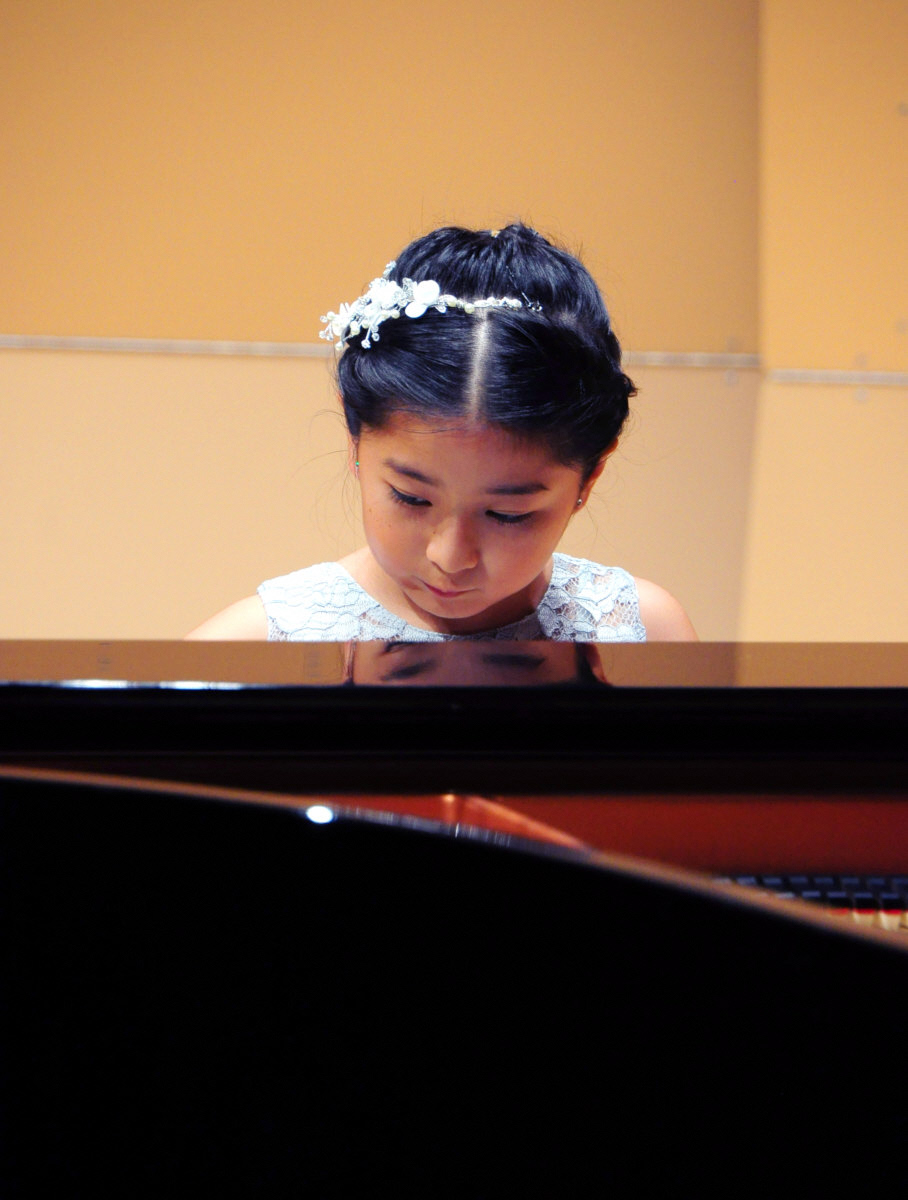 ステージでひとりピアノを弾く少女